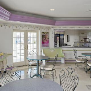 A bright and modern cafe interior featuring tables and chairs, with a welcoming atmosphere.