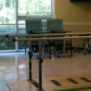 A physical therapy room equipped with parallel bars for rehabilitation exercises.