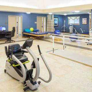 A well-equipped physical therapy room featuring various exercise and rehabilitation equipment.