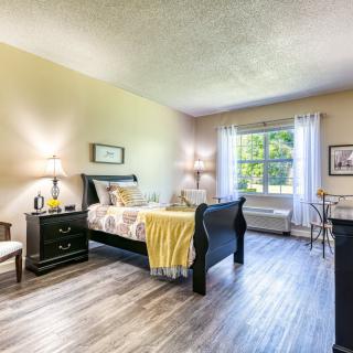 A cozy and modern bedroom with ample natural light and stylish furniture.