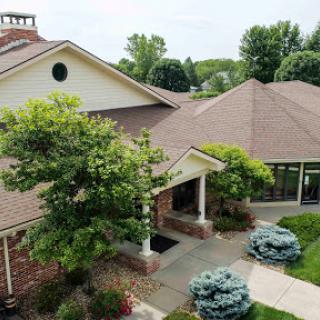 A picturesque view of a modern residential home, featuring lush landscaping and a welcoming entrance.
