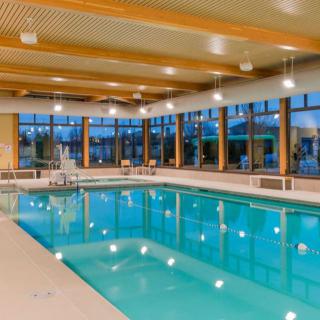 An inviting indoor swimming pool with modern architecture and ample lighting.