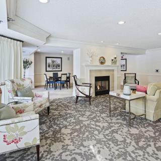 A cozy living room with stylish furniture and a central fireplace.