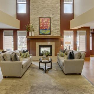 A spacious and elegantly designed living room featuring a central fireplace and modern sofas.
