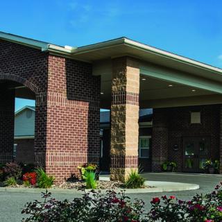 A brick building entrance with landscaping and plants.