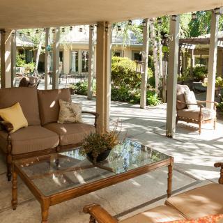 A cozy outdoor patio with comfortable seating and a garden view.