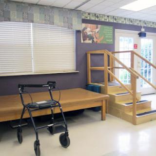 A rehabilitation space featuring a walker and a set of stairs for physical therapy.