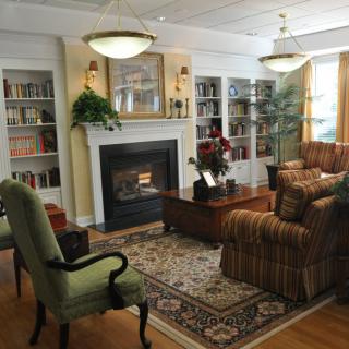 A cozy living room with a fireplace, bookshelves, and comfortable seating.