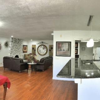 A spacious open floor plan featuring a modern living room and kitchen with hardwood floors and stylish decor.