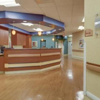 A hospital reception area with a wooden desk and hallway.