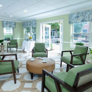 A cozy living room with green chairs and ample natural light.