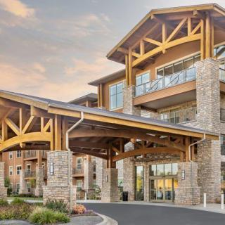 A modern building with a prominent wooden and stone entrance.