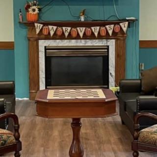 A cozy living room with a fireplace and autumn-themed decorations.