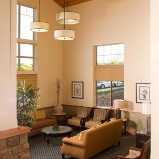 A modern lobby area with comfortable seating and large windows, featuring contemporary lighting and decor.