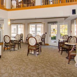A bright and elegant dining room with classic furniture and large windows.