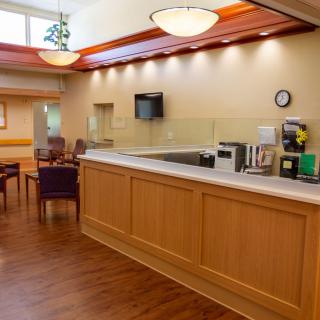 A well-lit reception area with seating and a counter.