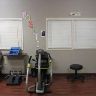 A gym interior featuring a stationary bike and motivational decor on the wall.
