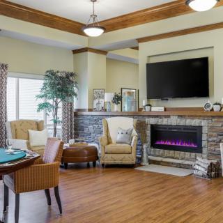 A modern living room with a fireplace and television, featuring comfortable seating and elegant decor.