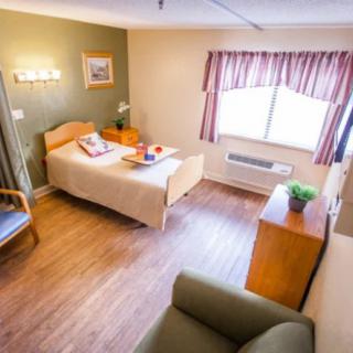 A cozy, well-furnished bedroom with a single bed and warm lighting.
