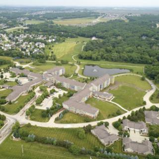 Aerial view of a suburban area with buildings, roads, and surrounding greenery.