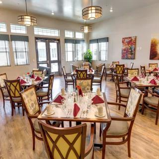 An elegant dining room with neatly arranged tables and chairs, set for guests.