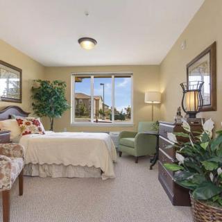 A cozy bedroom with elegant decor, featuring a large window allowing natural light to illuminate the room.
