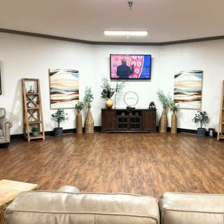 A modern living room with wood flooring, stylish decor, and a television mounted on the wall.