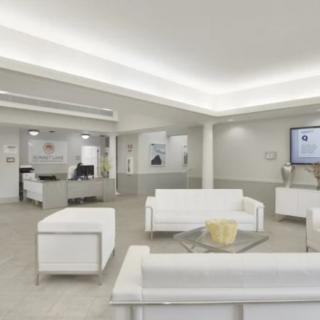 A modern and minimalist waiting room with white furniture and a clean design.
