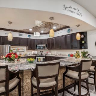 Modern kitchen with dark cabinetry and a central island featuring bar seating.