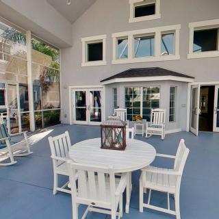 A spacious patio area with a dining set and a decorative lantern, surrounded by large windows.