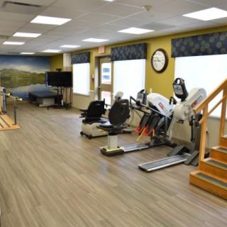 A rehabilitation center with various exercise equipment and therapy tools.