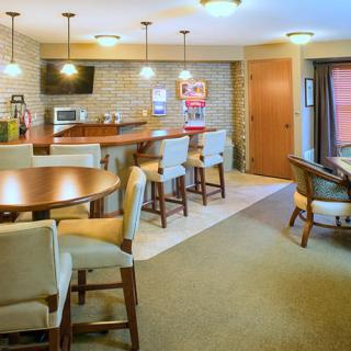A modern kitchen with a seating area featuring bar stools and a table with chairs.