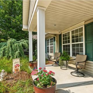 A welcoming front porch with outdoor seating and potted plants.