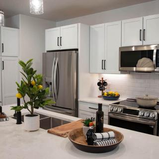 A modern kitchen with stainless steel appliances and white cabinets.