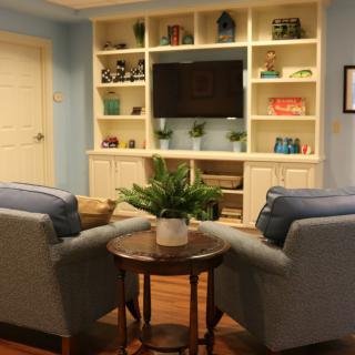 Cozy living room with armchairs and a built-in shelving unit featuring a TV and decorative items.