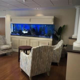 A cozy lobby with comfortable seating and a large, illuminated aquarium as the focal point.