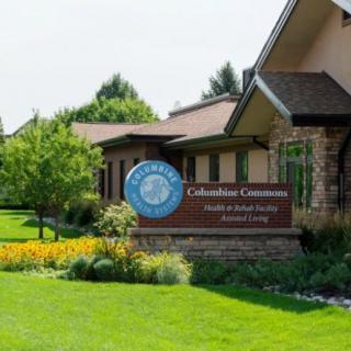 A well-maintained building with a sign reading 'Columbian Commons' and surrounding greenery.