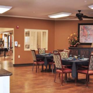 A cozy dining area with neatly arranged tables and chairs, featuring warm lighting and tasteful decor.