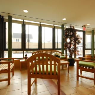 A bright waiting area with wooden chairs and large windows allowing natural light to fill the space.