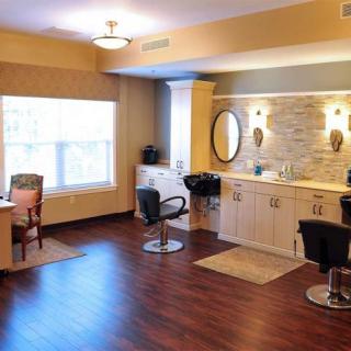 A well-lit salon interior featuring stylish chairs, mirrors, and wooden flooring.