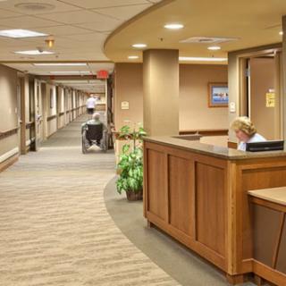 A hospital hallway featuring a reception desk and nurse station.