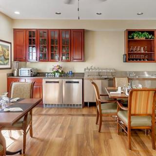 A cozy kitchen and dining area featuring wooden furniture, cabinets, and modern appliances.