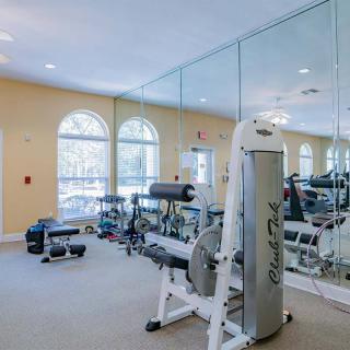A well-equipped gym with exercise machines and large mirrors.