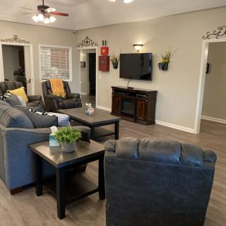A modern and cozy living room with comfortable seating and a mounted television.
