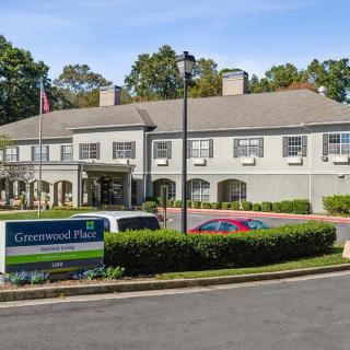 An exterior view of a commercial building with a parking area and well-maintained landscaping.