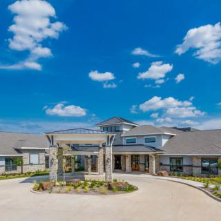 A scenic view of a modern building under a clear blue sky with clouds.