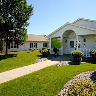 A well-maintained building with a green lawn and pathway leading up to the entrance.