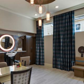 A modern salon interior with stylish lighting, a ring mirror, and comfortable seating.