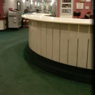 A view of a reception area featuring a circular counter and green carpet.