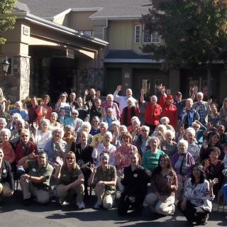 A large group of people gathered outside a building for a community event.